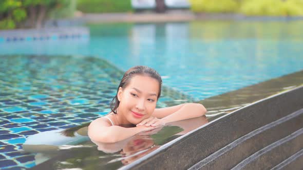 Young asian woman enjoy around outdoor swimming pool for leisure