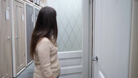 Brunette Woman Chooses Interior Doors in a Store