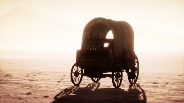 Canvas Covered Retro Wagon in Desert at Sunset