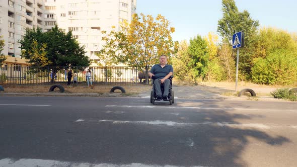 Wheelchair Man. Handicapped Man. a Young Disabled Man on an Automated Wheelchair Crosses the Road at