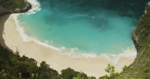 Close Up Slow Motion Shot of Waves Crashing on the Sandy Tropical Beach Kelingking Beach and TRex