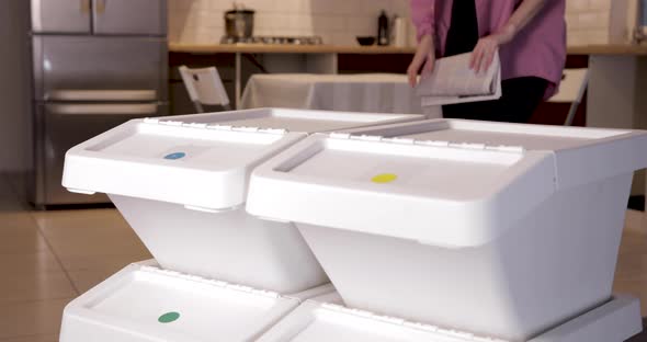 Young Woman Throwing Paper Waste Into Garbage Can for Recycling, Sorting System