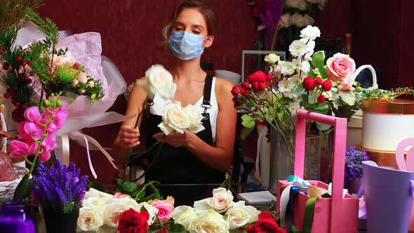 Florist Making Bouquet for a Client in Store in Spring Day Wearing Medical Mask