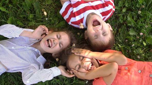 Happy Children Lying on the Grass Laughing Together, Slow Motion