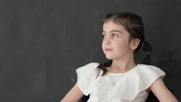 Portrait of a Little Girl in the Studio on a Black Background She Looks Into the Camera