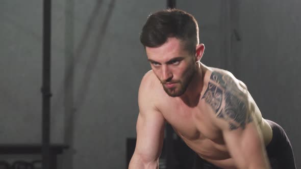 Focused Young Shirtless Male Athlete Doing Back Workout at the Gym