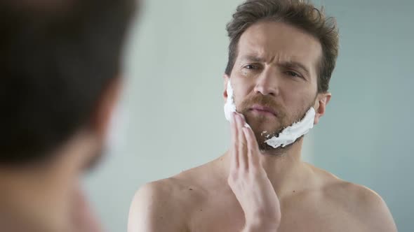 Middle-Aged Bearded Man Applying Shaving Foam on Face, Morning Ritual, Mirror