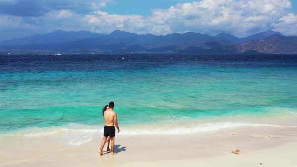 Two lovers relax on paradise resort beach lifestyle by blue ocean with white sand background of Gili