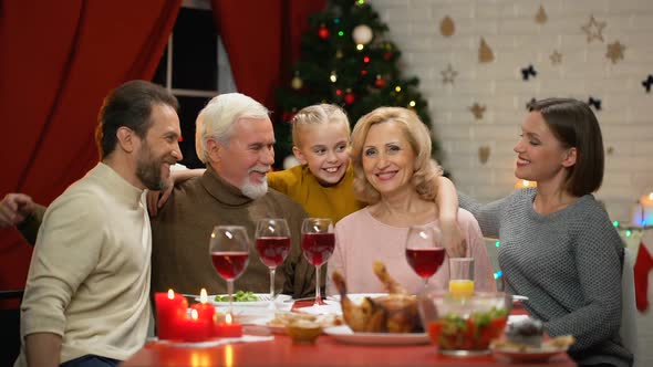 Little Girl Hugging Grandparents at Traditional Xmas Dinner, Retro Photo Effect