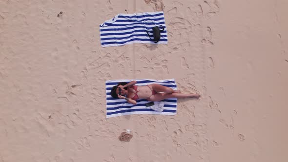 Drone Ofwoman In Bikini On Beach And Putting On Sunglasses