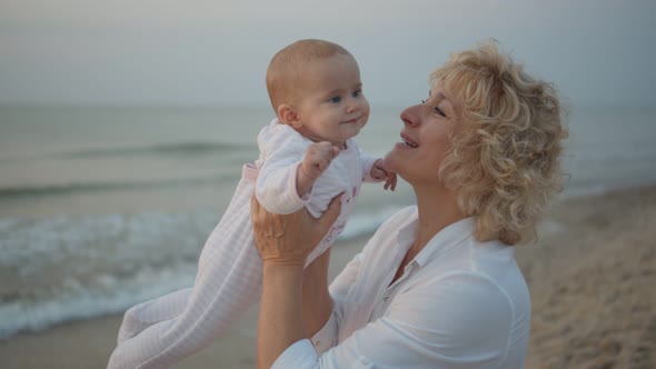 Grandmother Plays with a Newborn Baby