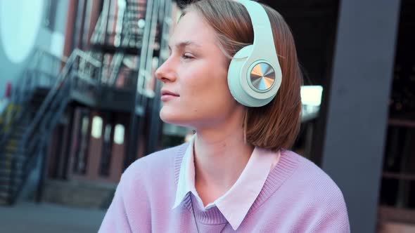 Melancholic Lady Student in Earphones Listens to Music