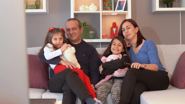 Family with children watching TV.