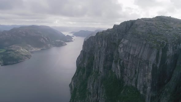 Aerial Slomo shot of Norwegian Mountains, revealing Fjord and a large bridge in the background, duri