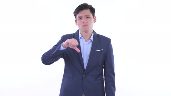 Sad Young Asian Businessman Giving Thumbs Down