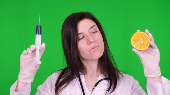 Young Female Doctor, Nutritionist Dressed in White Medical Uniform, with Stethoscope, Holding a Half