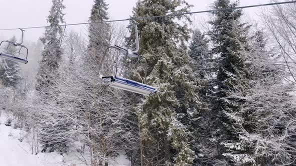 POV Empty Ski Lift Snowy Mountain Winter Forest with Chair Lift At The Ski Resort in Winter