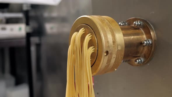 Tortiglioni Cazarece Spaghetti Pasta Falling From a Spout As They Travel Along the Production Line