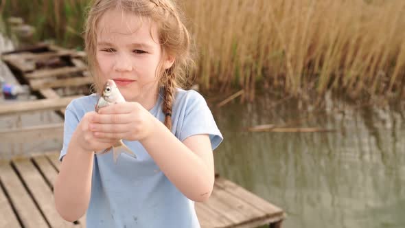 Little Girl Holding Fish That She Had Just Caught in River