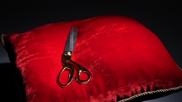 Golden Scissors Fall on a Red Pillow for Ceremonies. Rotation. Black. Slow Motion