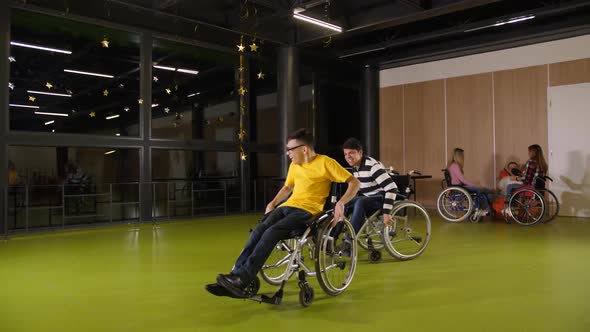 Joyful Teen Boys Having Fun Racing in Wheelchairs