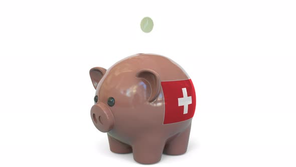 Putting Money Into Piggy Bank with Flag of Switzerland