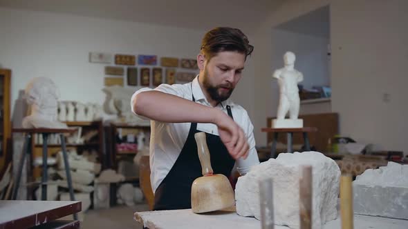 Professional Young Sculptor which Having a Rest while Working in the Craft Studio with Limestone