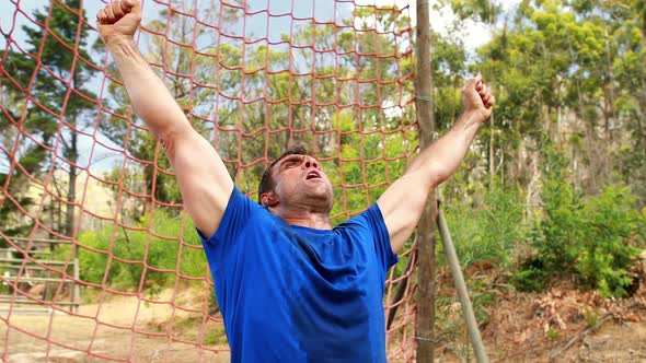 Fit man cheering during obstacle course