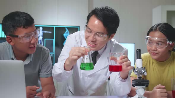 Young Asian Boy And Girl Learning Science Experiment With Teacher In Classroom