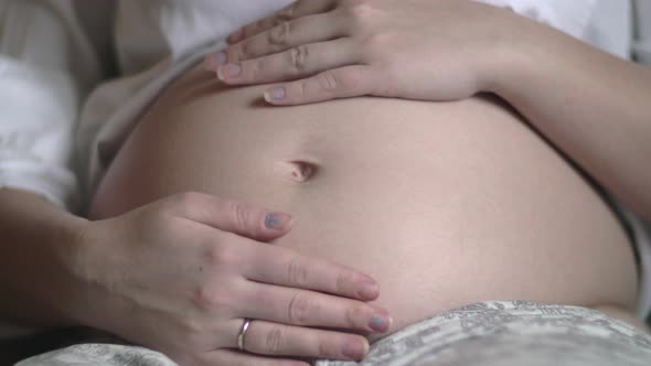 Pregnant woman touching and stroking belly