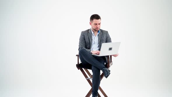 Young man sitting in a chair with laptop. 
