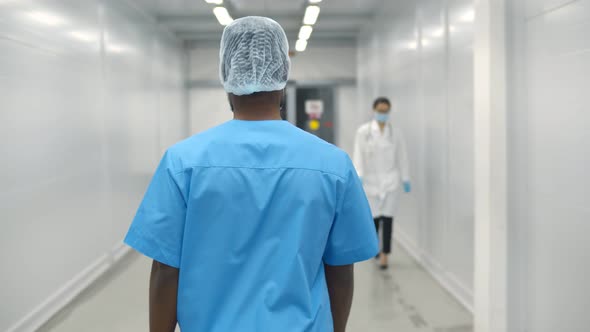 Back View of Afro-american Male Surgeon Walking Through Hospital Corridor