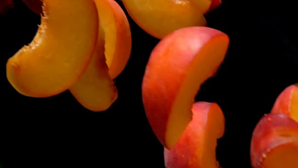 Peach Slices Fly Close-up on a Black Background