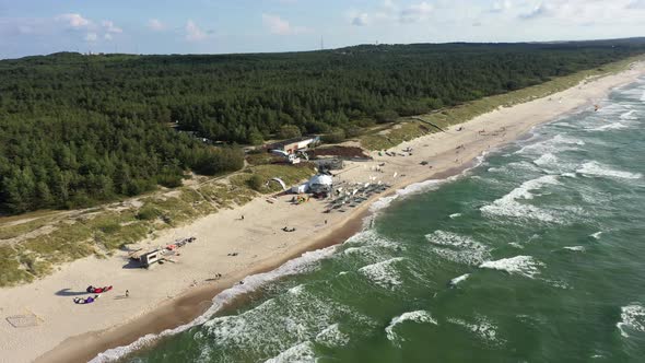 AERIAL: Rotating Shot of Surfers Riding Waves with Kites on a Sunny Day