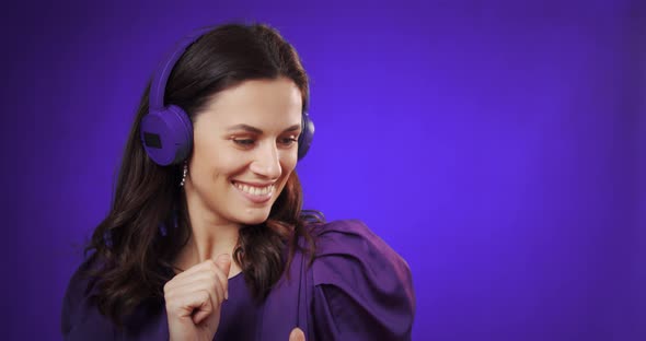 Happy Young Woman Listen Music in Headphones at Studio