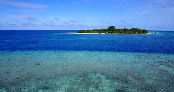 Natural flying travel shot of a sunshine white sandy paradise beach and blue water background in hi 