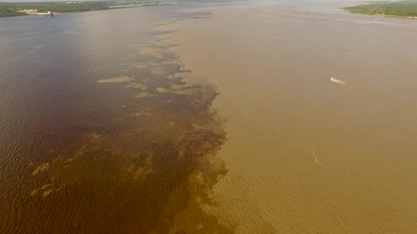 Slow cinematic aerial high above the confluence of the Black River and Amazon River