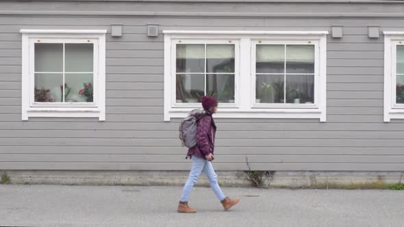 Woman walking in front of houses in Haugesund, Norway