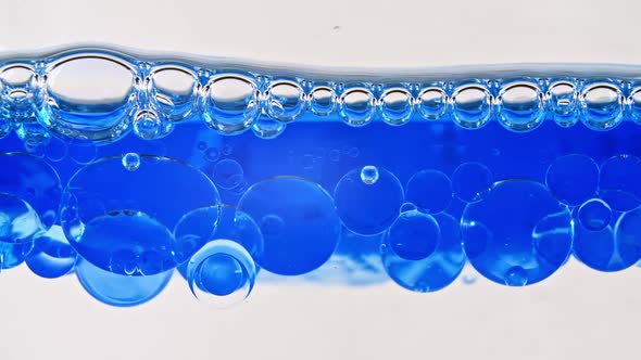 Macro Shot of Various Air Bubbles in Water Rising Up on Light White Background