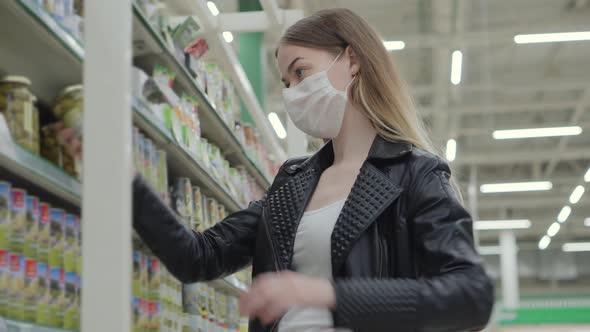 Young Lady in Medical Mask Buying Ketchup in Grocery Shop