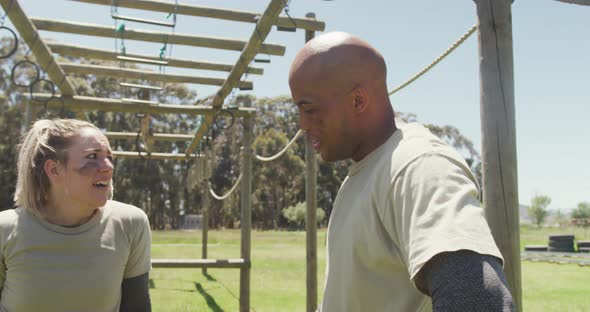 Tired, diverse male and female soldier resting on army obstacle course in sun alt