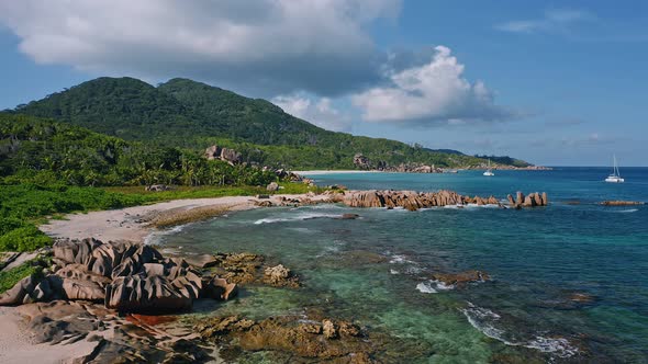 Aerial Drone Footage of La Digue Tropical Island with Beautiful Coast and Lonely Catamaran Yacht