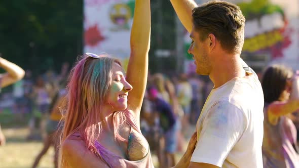 Two Sweethearts Dancing in a Crowd at Summer Traditional Festival of Colors