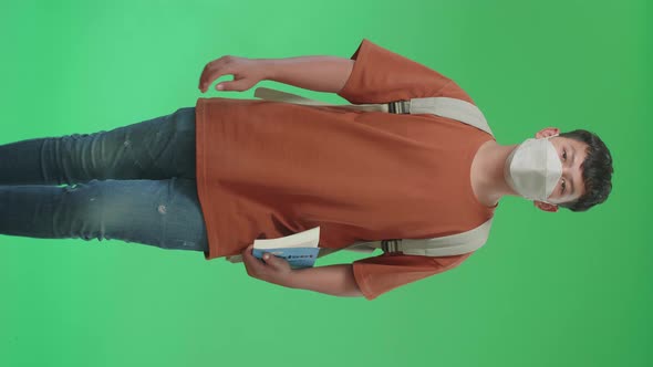 Asian Boy Student Wearing A Mask, Holding A Book And Walking On Green Screen Chroma Key