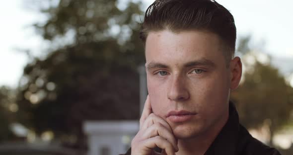 Portrait of Young Sad Pensive Man Looking at Camera While Standing Outdoors Alone. Attractive