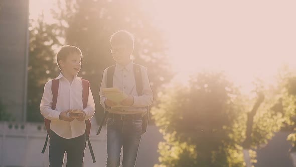 Students in School Uniform with Bags Walk Along Street