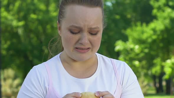 Young Woman Suffering From Desire to Eat Fresh Burger, Forgetting About Diet