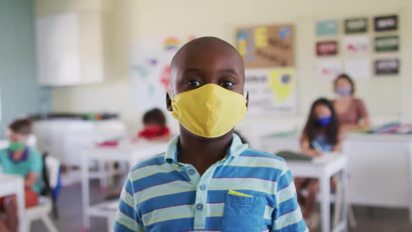 Portrait of boy wearing face mask in class at school