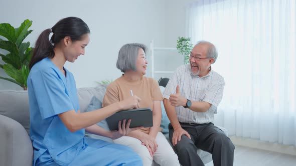 Asian caregiver nurse examine senior woman patient and husband at home.