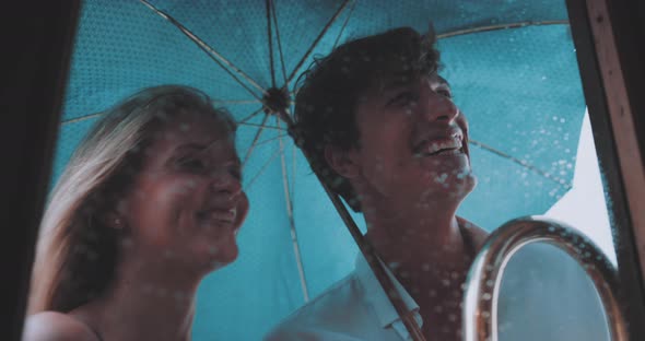 Couple holding umbrella look into the restaurant